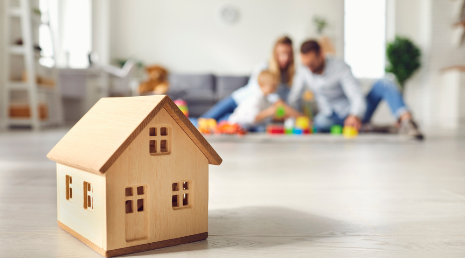 wooden toy house with family in the background
